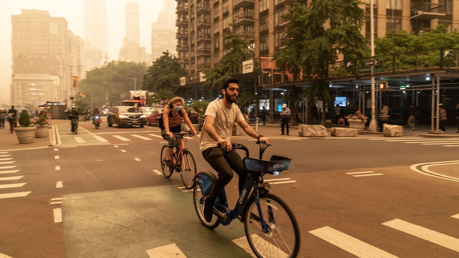 Two cyclists navigate smoggy streets in New York City (Credit: Getty Images)
