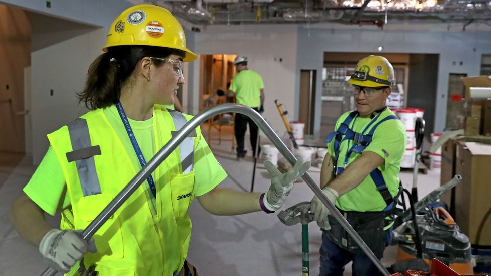 Alicia Miksic, an apprentice electrician, bends an electrical pipe with electrician Adam DeFilippo in Boston in 2020 (Credit: Getty Images)